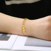 Femme portant un bracelet Croix de Vie Ankh maillons or au poignet