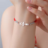 Femme portant un bracelet Croix de Vie Ankh cordon rouge argent au poignet
