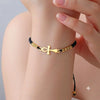 Femme portant un bracelet Croix de Vie Ankh or cordon noir au poignet