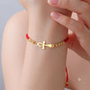Femme portant un bracelet Croix de Vie Ankh cordon rouge or au poignet
